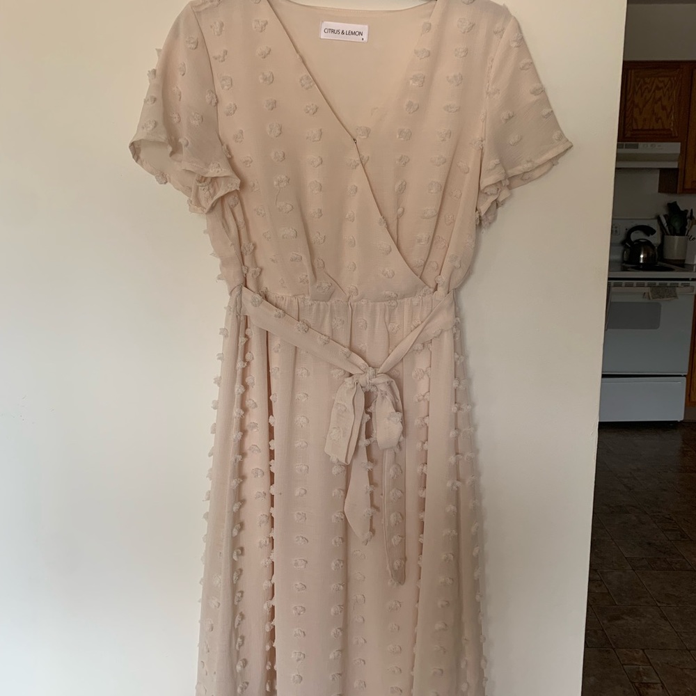 Cream colored faux-wrap dress with 3D detail